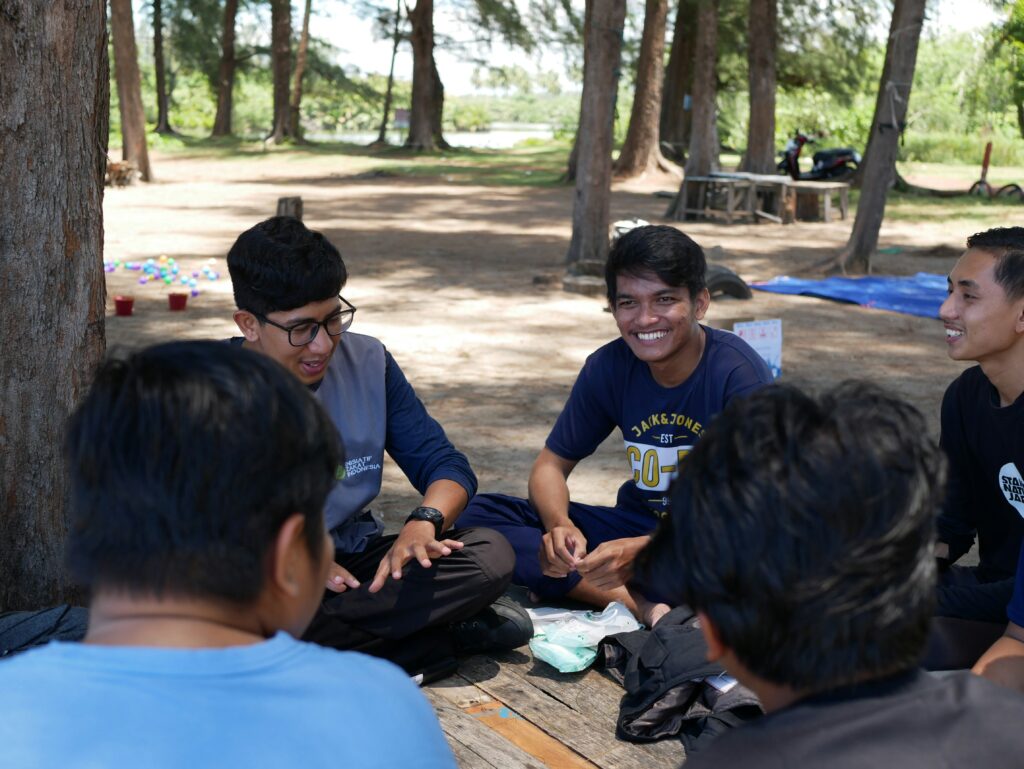 herlambang-tinasih-gusti-zF9jfGe1Vf4-unsplash a group of young men sitting on top of a picnic table